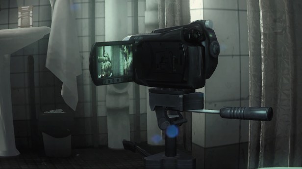 A shot of a camcorder on a tripod. The viewfinder shows Kane and Lynch being tortured with a box cutter. They're both nude.